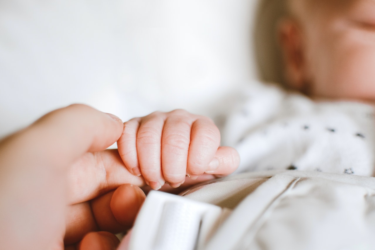 Adulte qui tient la main d'un bébé